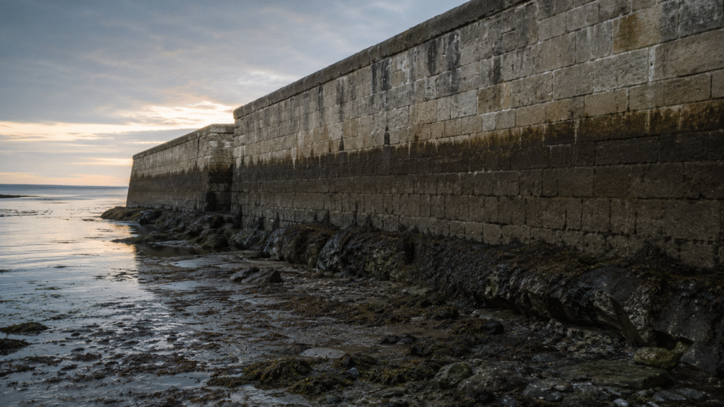 Stone harbor wall at low tide with a high-water mark, marking the Treasury buyback week the 30-year yield peaked at 5.31 percent